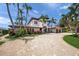 Stunning two-story Mediterranean-style home featuring a circular driveway, lush landscaping, and a three car garage at 3576 San Remo Ter, Sarasota, FL 34239