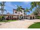 Stunning two-story Mediterranean-style home featuring a circular driveway, lush landscaping, and a three car garage at 3576 San Remo Ter, Sarasota, FL 34239