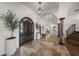 Elegant foyer featuring travertine floors, a dark wood front door, and an olive tree in a pot at 3576 San Remo Ter, Sarasota, FL 34239