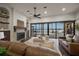 Bright living room with water view through large sliding glass doors and a cozy stone fireplace at 3576 San Remo Ter, Sarasota, FL 34239