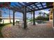 Outdoor seating area near the pool, featuring mature landscaping, water views and a dark pergola at 3576 San Remo Ter, Sarasota, FL 34239