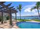 Side view of the pool with outdoor seating beneath a pergola overlooking the waterfront at 3576 San Remo Ter, Sarasota, FL 34239