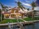Elegant rear exterior showcases a private pool, boat dock, and Mediterranean design amidst lush tropical landscaping at 3576 San Remo Ter, Sarasota, FL 34239