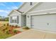 A close up of a charming home featuring a two-car garage, a well manicured lawn, and lovely landscaping at 3834 Silver Strand Trl, Palmetto, FL 34221