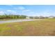 A scenic pond with a fountain is surrounded by lush green grass and several houses in the distance at 3834 Silver Strand Trl, Palmetto, FL 34221