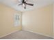 A bright bedroom features a window and ceiling fan with neutral walls and carpet at 4012 Willow Hammock Dr, Palmetto, FL 34221