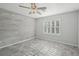 This bedroom features gray flooring, a ceiling fan, and natural light at 4012 Willow Hammock Dr, Palmetto, FL 34221