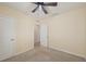A bright bedroom features a modern ceiling fan and two entryways with neutral walls and carpet at 4012 Willow Hammock Dr, Palmetto, FL 34221