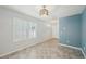 Bright living room features shuttered window, stylish lighting, and gray flooring at 4012 Willow Hammock Dr, Palmetto, FL 34221