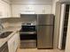 Well-lit kitchen featuring stainless steel appliances, white cabinets, and stone countertops at 4035 S School Ave # D3, Sarasota, FL 34231