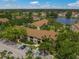 An aerial view of the condo community with waterfront views, ample parking and mature trees at 4037 Crockers Lake Blvd # 17, Sarasota, FL 34238
