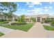Community clubhouse featuring lush landscaping, a central fountain, and a welcoming entrance at 4037 Crockers Lake Blvd # 17, Sarasota, FL 34238
