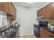 Well-lit kitchen features stainless steel sink, black oven, stone countertops and tiled backsplash at 4037 Crockers Lake Blvd # 17, Sarasota, FL 34238