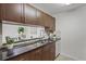 Kitchen sink with granite counters, cabinets, tiled backsplash, and a view to the dining area at 4037 Crockers Lake Blvd # 17, Sarasota, FL 34238