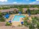Aerial view of a community pool with sundeck, cabana, seating areas and manicured landscaping at 4037 Crockers Lake Blvd # 17, Sarasota, FL 34238