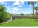 Scenic water view featuring a wooden dock, lush green lawn, and tranquil lake in a residential community at 4037 Crockers Lake Blvd # 17, Sarasota, FL 34238