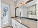 Bathroom featuring a white vanity, a large mirror, and a door to the outside at 4312 Vasco St, Punta Gorda, FL 33950