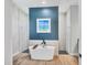 Modern bathroom featuring soaking tub, a blue accent wall with picture, and dual walk-in showers at 4312 Vasco St, Punta Gorda, FL 33950