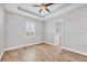 The bedroom has wood floors, a ceiling fan, a window with blinds and an ensuite bathroom at 4312 Vasco St, Punta Gorda, FL 33950