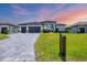 Stunning one-story home with a large driveway, three-car garage, dark gray roof, and lush green lawn at 4312 Vasco St, Punta Gorda, FL 33950