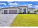 Modern home with a three-car garage, attractive landscaping, and a paver driveway at 4312 Vasco St, Punta Gorda, FL 33950