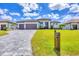 Beautiful home with a three-car garage, attractive landscaping, and a gray brick driveway at 4312 Vasco St, Punta Gorda, FL 33950