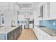 Modern kitchen features an island with seating, stainless steel appliances, and stylish blue backsplash at 4312 Vasco St, Punta Gorda, FL 33950