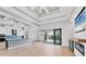 Open living room with high coffered ceilings, wood floors, a modern fireplace, and doors leading to the pool area at 4312 Vasco St, Punta Gorda, FL 33950