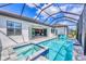 A screened pool and spa with turquoise water are the highlights of the pool deck with access to the home's interior at 4312 Vasco St, Punta Gorda, FL 33950