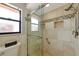 Modern bathroom features a walk-in shower with glass doors and tiled walls with a decorative accent stripe and niches at 4471 Atwood Cay Cir # 13, Sarasota, FL 34233