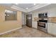 Well-equipped kitchen featuring stainless appliances and travertine tile flooring at 4471 Atwood Cay Cir # 13, Sarasota, FL 34233