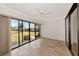 Bright living room with neutral paint, tile flooring, ceiling fan, and a sliding glass door to screened patio at 4471 Atwood Cay Cir # 13, Sarasota, FL 34233