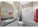 Well-lit bathroom with a granite-topped vanity, an oval sink and a shower/tub combination with a white shower curtain at 4542 Cedar Brush Ter, Sarasota, FL 34243