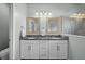 Bright bathroom with a double sink vanity, granite countertops, framed mirrors and a glass shower with tile surround at 4542 Cedar Brush Ter, Sarasota, FL 34243