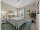 Cozy bedroom with a white bed, bright pillows, colorful paintings and a large plant next to the window at 4542 Cedar Brush Ter, Sarasota, FL 34243