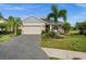 Charming single-story home with a well-manicured lawn, palm trees, and a two-car garage at 4542 Cedar Brush Ter, Sarasota, FL 34243