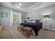 Tranquil main bedroom with a tray ceiling, bedside tables with lamps, and a view of the backyard at 4542 Cedar Brush Ter, Sarasota, FL 34243
