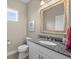 Half bathroom with a granite-topped vanity, an oval sink, tan walls, and a framed mirror at 4542 Cedar Brush Ter, Sarasota, FL 34243