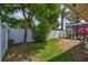 Exterior view of home's side yard with white fence and mature landscaping at 5126 15Th W Ave, Bradenton, FL 34209