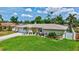Charming home with a well-manicured lawn and landscaping, including palm trees and colorful flower beds at 5126 15Th W Ave, Bradenton, FL 34209