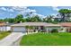 Charming home with a well-manicured lawn and landscaping, including palm trees and colorful flower beds at 5126 15Th W Ave, Bradenton, FL 34209