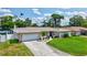 Charming home with a well-manicured lawn and landscaping, including palm trees and colorful flower beds at 5126 15Th W Ave, Bradenton, FL 34209