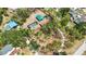 Aerial view of a home with lush trees, a pool, and a detached garage on a large lot at 5204 24Th E Ave, Palmetto, FL 34221