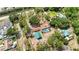 Aerial view of the property showcases the screened-in pool, covered parking, and spacious lot surrounded by trees at 5204 24Th E Ave, Palmetto, FL 34221