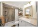 A remodeled bathroom featuring a new vanity with quartz countertop, a gold trimmed mirror, and a tiled walk-in shower at 5204 24Th E Ave, Palmetto, FL 34221