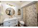 Bright bathroom featuring a round mirror, modern vanity, and floral shower curtain at 5204 24Th E Ave, Palmetto, FL 34221