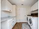 Bright laundry room offers extra cabinets, counterspace, and a modern washer and dryer for easy laundry days at 5204 24Th E Ave, Palmetto, FL 34221
