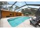 A spacious screened-in pool area featuring a spa, seating, and a seamless transition to the backyard at 5204 24Th E Ave, Palmetto, FL 34221