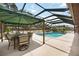 Screened-in pool area with outdoor dining and additional seating under a green canopy at 5204 24Th E Ave, Palmetto, FL 34221