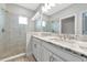 Bathroom with a double sink vanity featuring a granite countertop and large walk-in shower at 5561 Cannes Cir # 5101, Sarasota, FL 34231